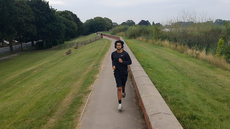 A person jogging on a paved path in a park.
